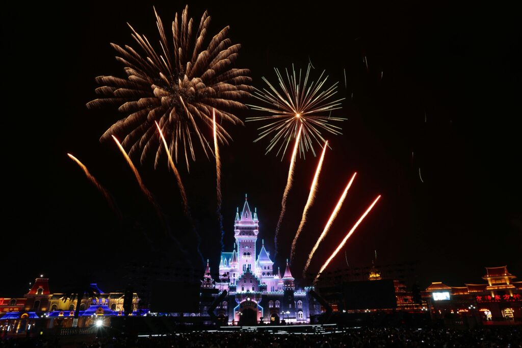 Spectacular fireworks display over a fairy-tale castle, lighting up the night sky.